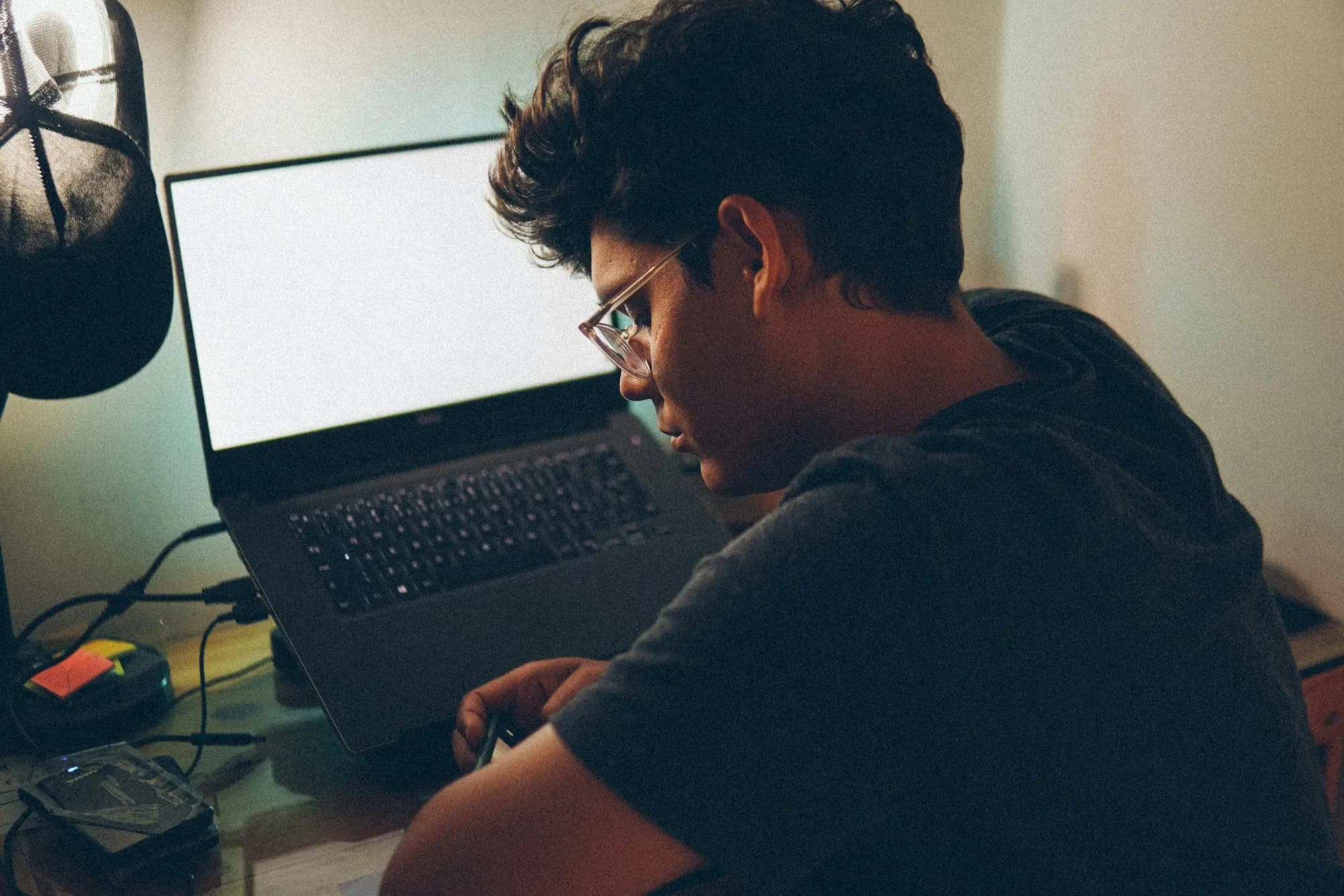 A student studying at a laptop late at night