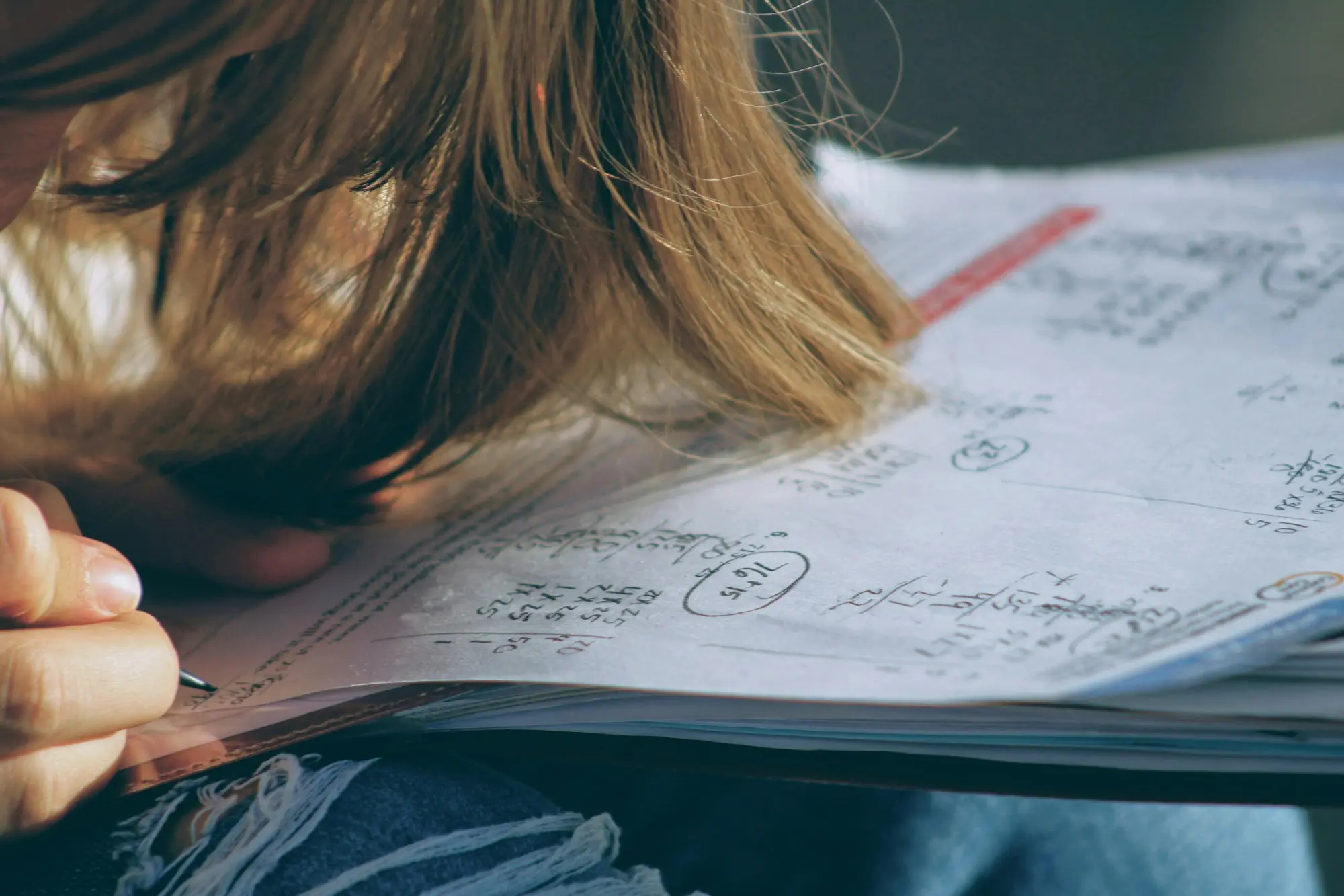 A student working through a sheet of maths problems